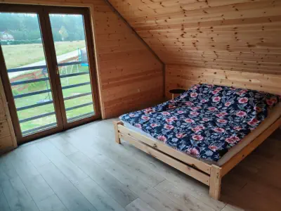 Zdjęcie sypialni - widoczne duże dwuosobowe łóżko oraz wyjście na balkon